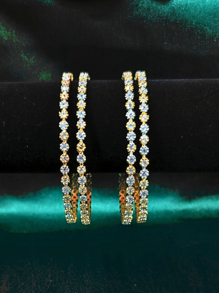 Close-up of an ornate Indo-western (Gold & Silver Polish) Bangles set with American Diamond. Close-up of premium imitation American Diamond bangles styled with a silk saree. Festive celebration look enhanced with statement artificial American Diamond bangles.