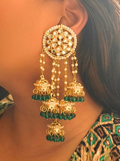 Close-up of a woman wearing an ornate traditional (Gold Polish) Teel Long  Earrings with Kundan, Pearls and Teel Beads Mehendi ceremony look completed with a handcrafted Kundan Earrings. Wedding celebration look enhanced with a statement Kundan Earrings.