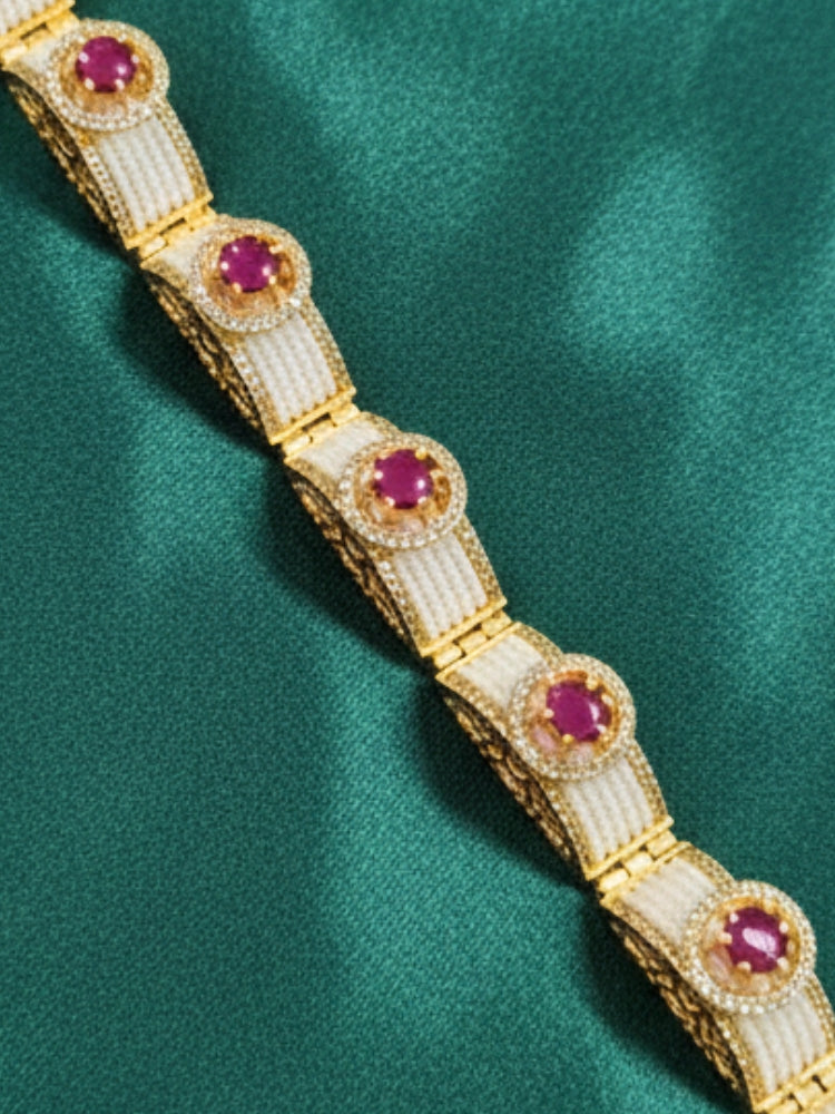 Close-up of a woman wearing an ornate Traditional Diamond Bracelet with Gold Polish, Pink Colored Stones, American Diamond, Pearls and filigree Work. Reception-ready look featuring a statement American diamond Bracelet. Close-up of a cocktail party look featuring a premium American diamond Bracelet.