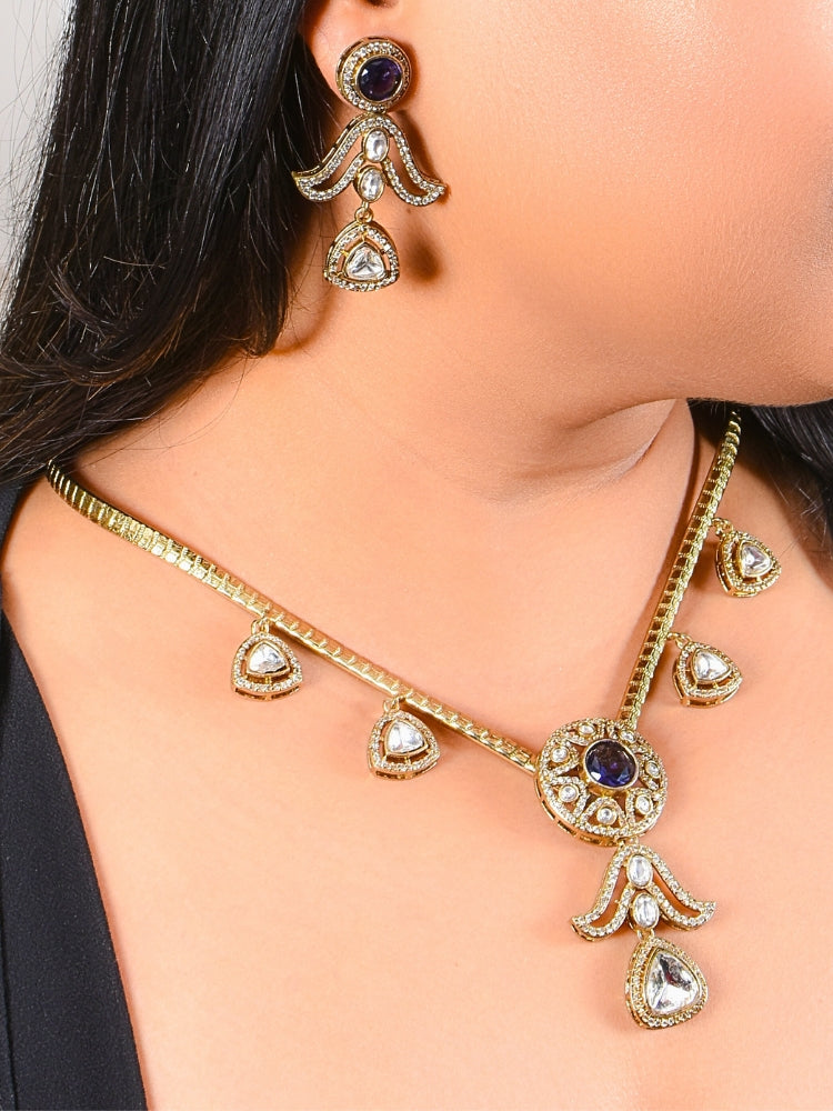 A woman wearing the Orchid Hasli Purple Necklace Set, which features intricate gold Kundan work with american diamonds and purple stones, matching drop earrings, and paired with a black top for a traditional, ornate look.