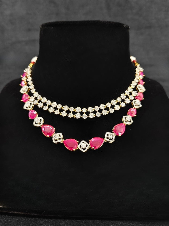 A glamorous artificial diamond and pink colored stone necklace paired with chic earrings, perfect for bridal wear. This high-quality artificial diamond jewelry set is the ideal choice for modern brides looking for a budget-friendly option with timeless sparkle.
