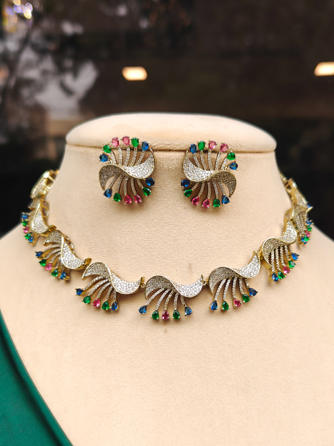 "A woman in a traditional saree, wearing a gorgeous artificial diamond and colored stone necklace paired with diamond earrings. This artificial diamond jewelry set offers a traditional yet modern touch for Indian brides, designed to add elegance and sophistication to any occasion."