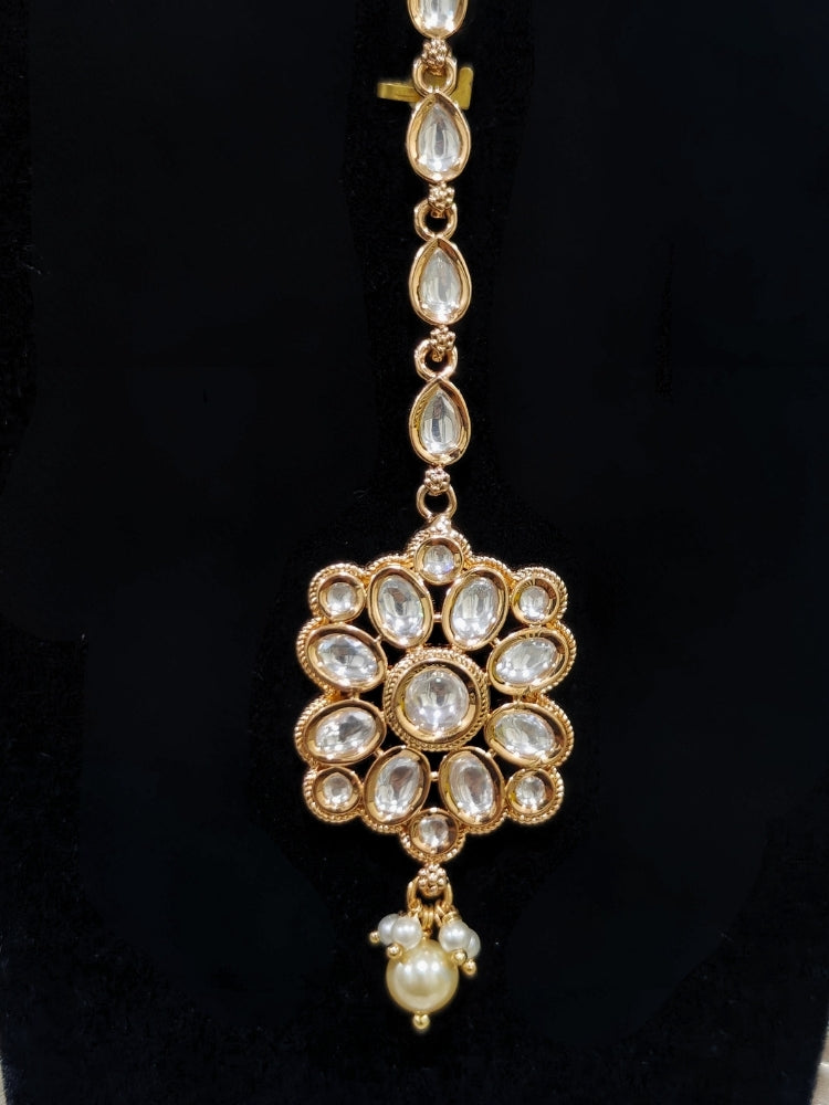 Close-up of an ornate traditional (Gold Polish) Collar White jewellery set and earrings and maangtikka with Polki and Pearl. Wedding guest wearing a statement Polki artificial necklace for a reception party. Woman styling a premium Polki imitation necklace for wedding celebrations.