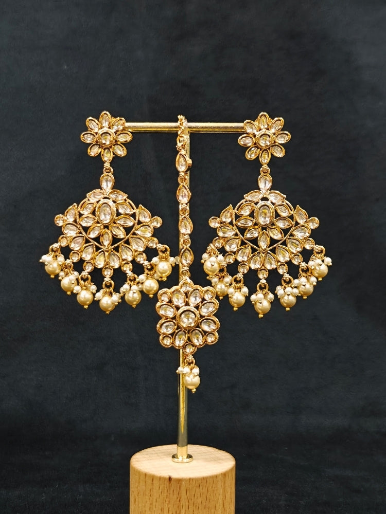 Close-up of an ornate traditional (Gold Polish) Collar White jewellery set and earrings and maangtikka with Polki and Pearl. Wedding guest wearing a statement Polki artificial necklace for a reception party. Woman styling a premium Polki imitation necklace for wedding celebrations.