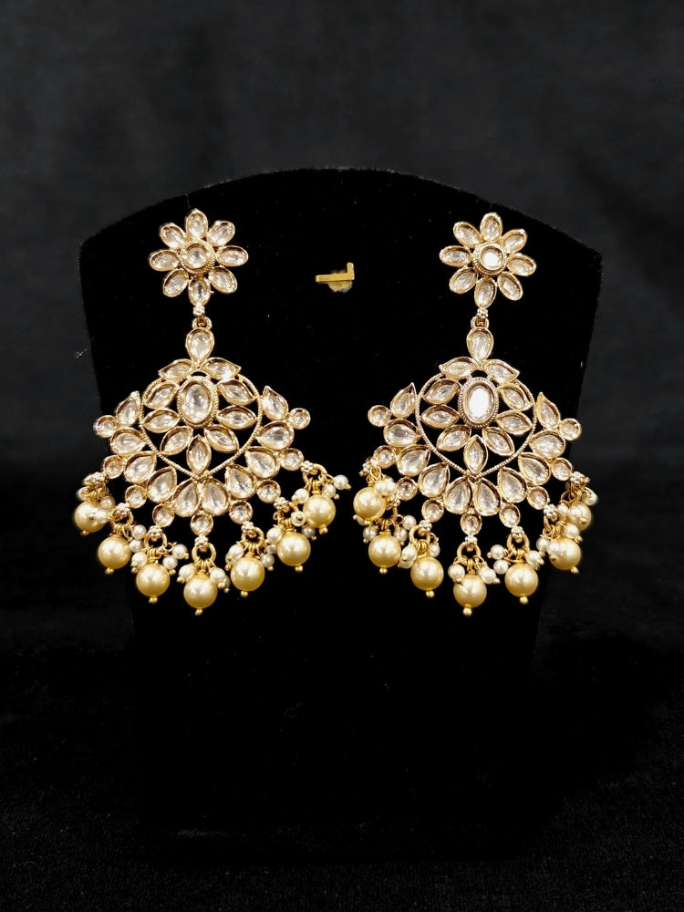Close-up of an ornate traditional (Gold Polish) Collar White jewellery set and earrings and maangtikka with Polki and Pearl. Wedding guest wearing a statement Polki artificial necklace for a reception party. Woman styling a premium Polki imitation necklace for wedding celebrations.