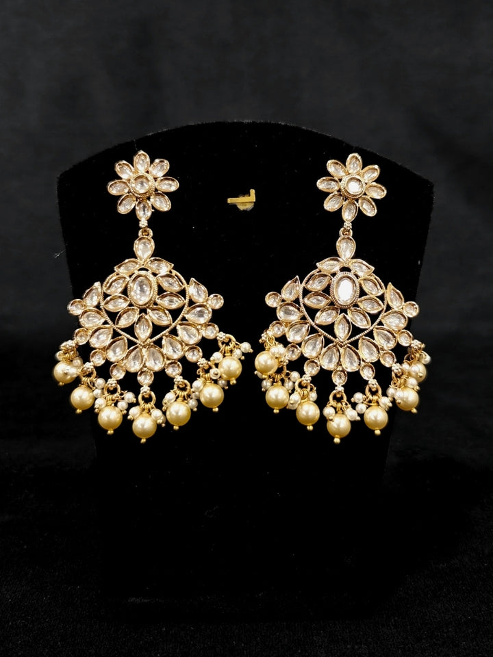 Close-up of an ornate traditional (Gold Polish) Collar White jewellery set and earrings and maangtikka with Polki and Pearl. Wedding guest wearing a statement Polki artificial necklace for a reception party. Woman styling a premium Polki imitation necklace for wedding celebrations.