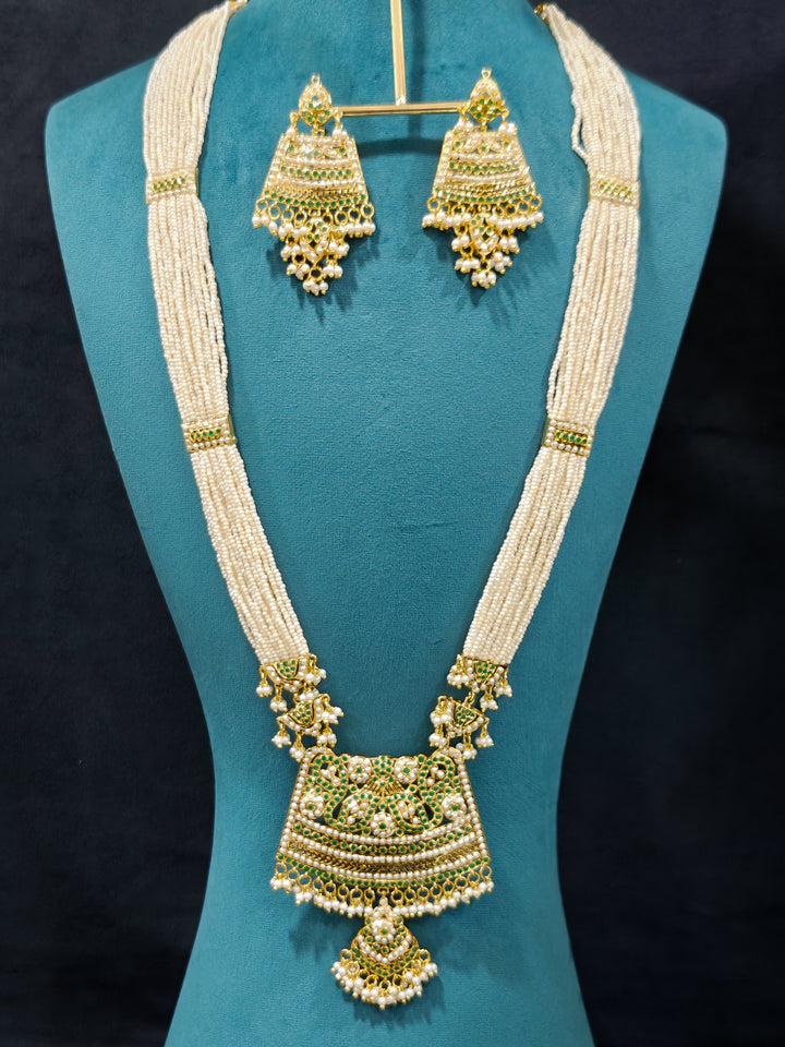 Close-up of high-quality long Jadau artificial necklace with matched Earring craftsmanship. a royal Jadau necklace for festive events in India and traditional Indian wedding. elegant green Jadau long necklace, adorned with delicate pearls and intricate detailing, adds a royal charm to any traditional look.

