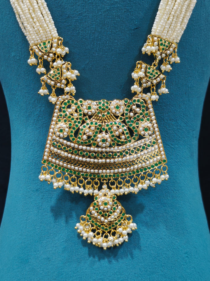 Close-up of high-quality long Jadau artificial necklace craftsmanship. a royal Jadau necklace for festive events in India and traditional Indian wedding. elegant green Jadau long necklace, adorned with delicate pearls and intricate detailing, adds a royal charm to any traditional look.

