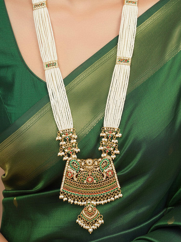 Close-up of a woman wearing an ornate handmade long jadau jewelry set and earrings with multicolor jadau gemstones. This is a perfect jadau jewelry set for weddings, festivals and more. Can also be worn as bridal jadau jewelry for indian weddings. 