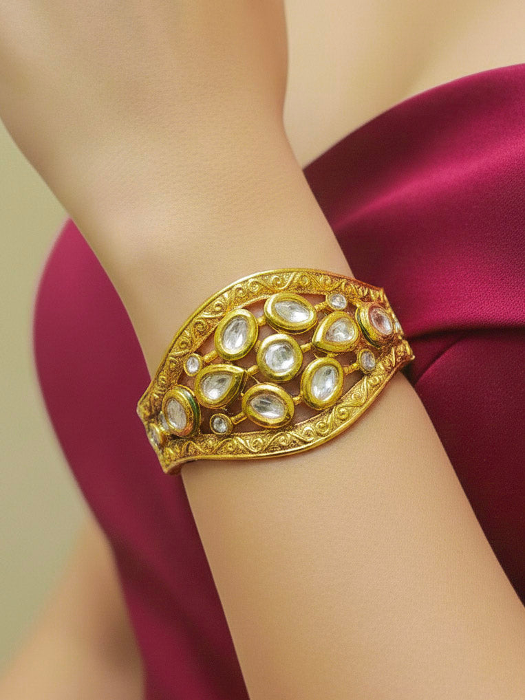 Close-up of a woman wearing an ornate traditional (Gold Polish) Bracelet with Kundan. Close-up of a high-quality imitation Kundan bracelet for festive wear. Wedding guest wearing a minimal artificial Kundan bracelet. Perfect for Wedding function and Festive.