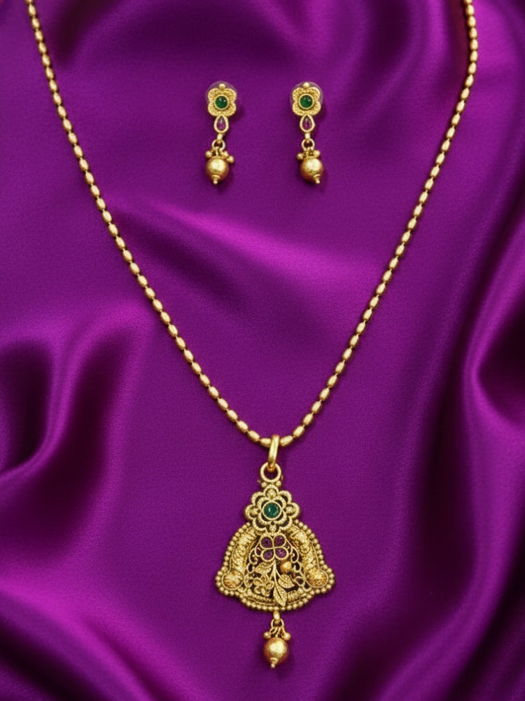 Close-up of an ornate traditional (Gold Polish) jewellery set and earrings with Pink & Green Colored Stones. Saree look completed with an elegant Colored Stone artificial jewelry piece. Festive Diwali outfit paired with a colorful Colored Stone necklace.