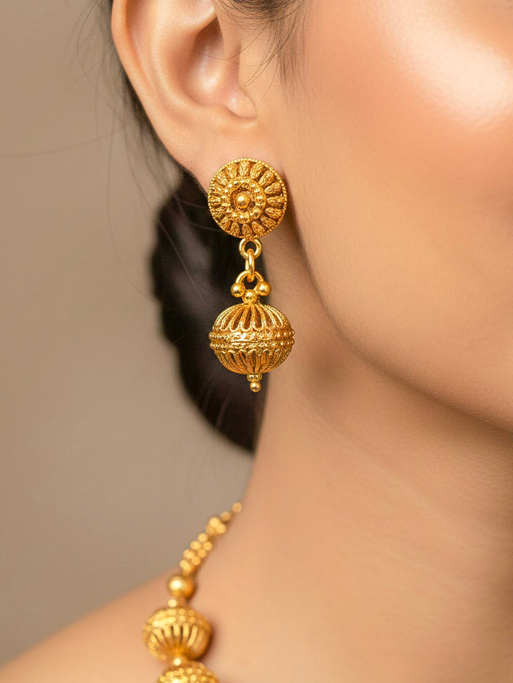 Close-up of a woman wearing an ornate traditional (Bright Gold Polish) Long jewellery set and earrings with Filigree Balls. Woman styling a vibrant Meenakari Filigree necklace with a festive saree. Festive celebration look enhanced with traditional Filigree jewelry.