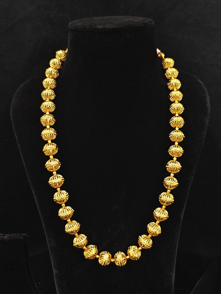 Close-up of an ornate traditional (Bright Gold Polish) Long jewellery set and earrings with Filigree Balls. Woman styling a vibrant Meenakari Filigree necklace with a festive saree. Festive celebration look enhanced with traditional Filigree jewelry.