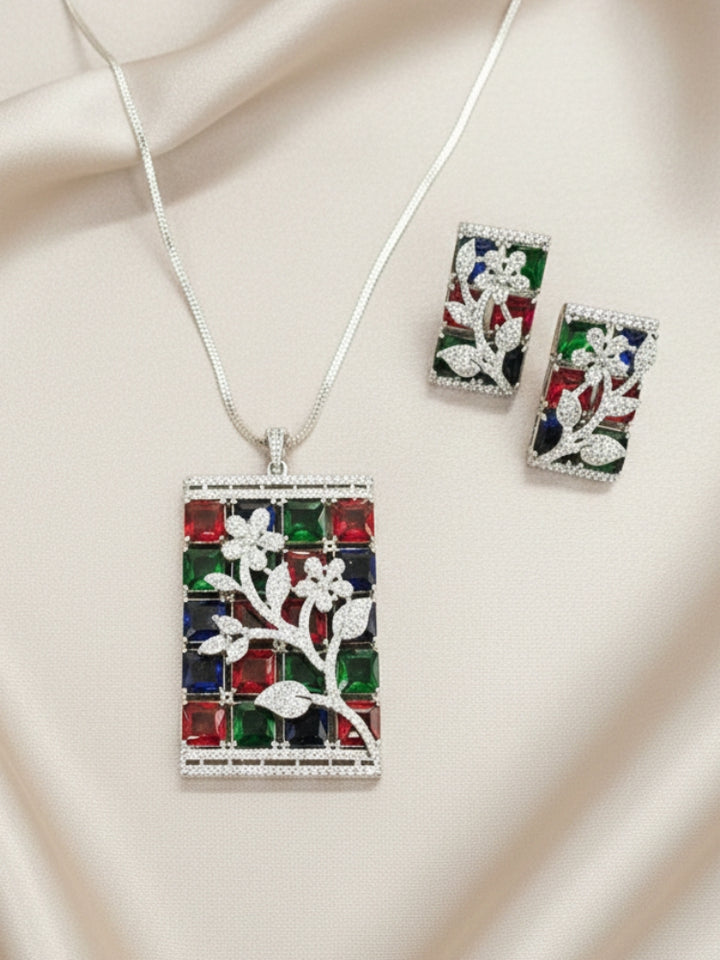 Close-up of an ornate Western (Silver Polish) Colored Stones Pendant set and earrings with American Diamond and Colored Stones. A luxury artificial Colored Stones Pendant Set for Party. Reception-ready look featuring a statement Colored Stones Pendant set.