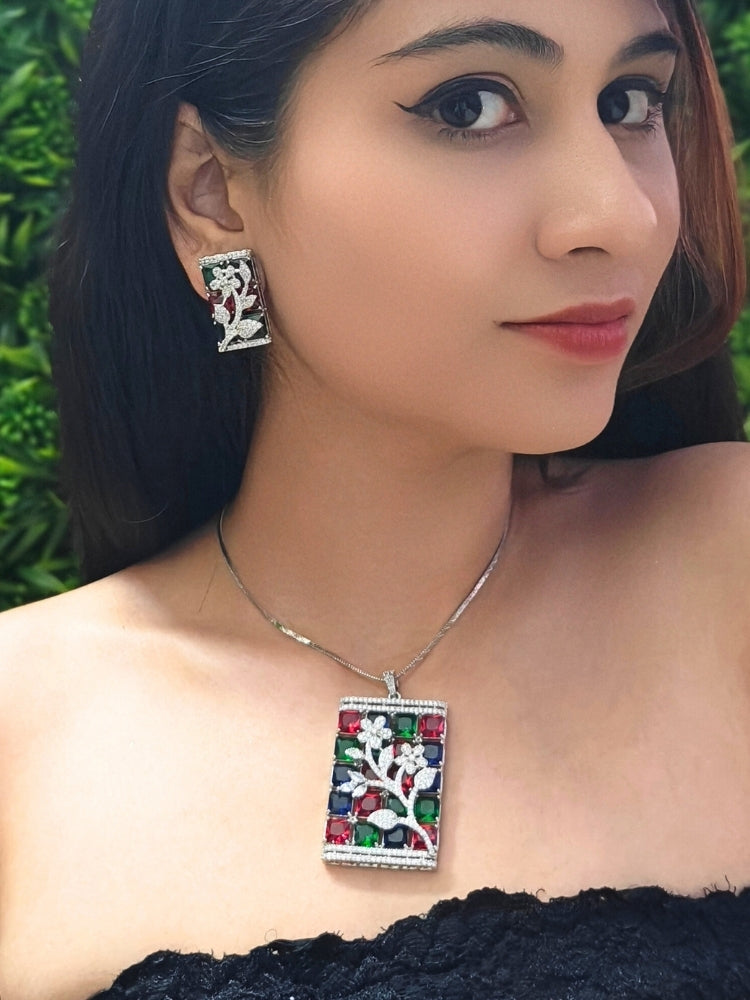 Close-up of a woman wearing an ornate Western (Silver Polish) Colored Stones Pendant set and earrings with American Diamond and Colored Stones. Modern  styled in a luxury artificial Colored Stones Pendant Set for Party. Reception-ready look featuring a statement Colored Stones Pendant set.