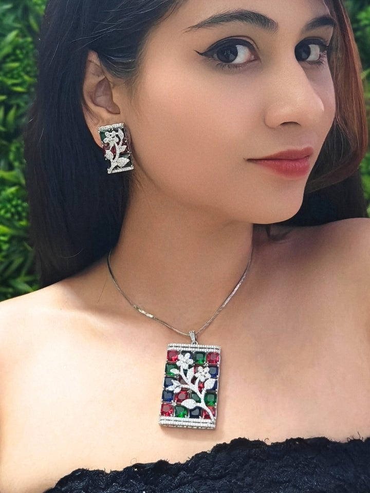Close-up of a woman wearing an ornate Western (Silver Polish) Colored Stones Pendant set and earrings with American Diamond and Colored Stones. Modern  styled in a luxury artificial Colored Stones Pendant Set for Party. Reception-ready look featuring a statement Colored Stones Pendant set.
