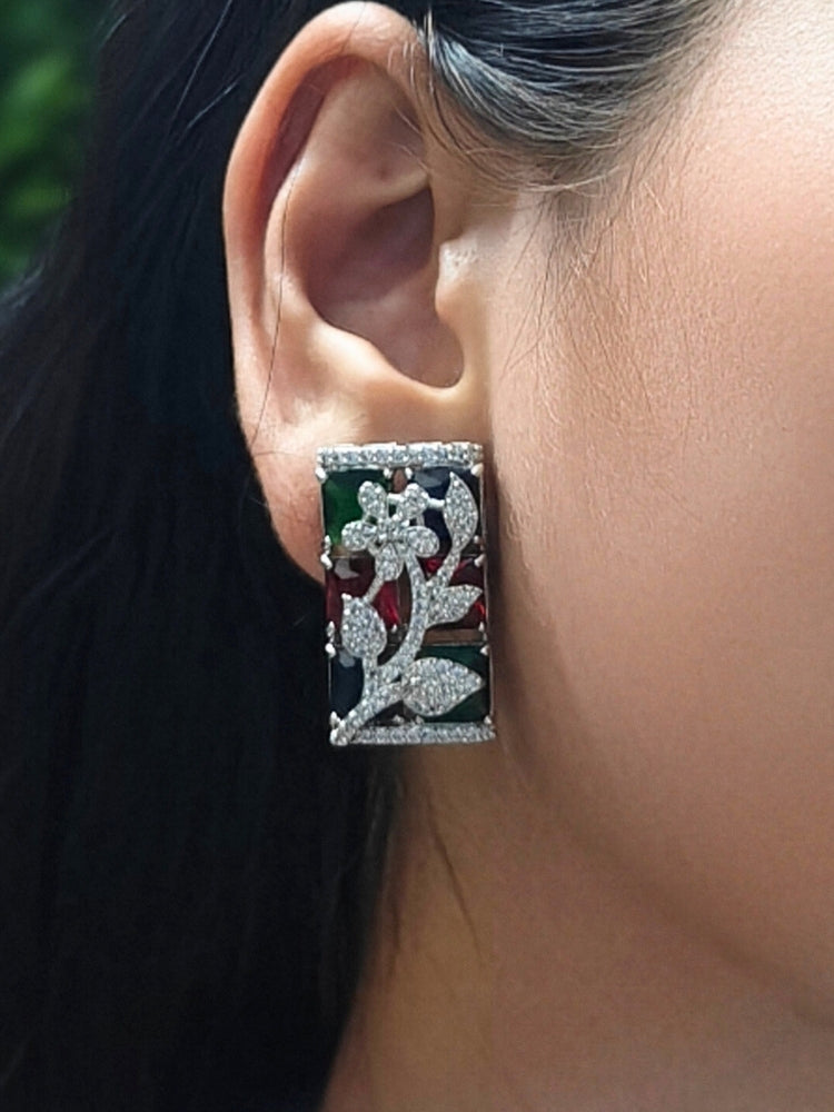 Close-up of a woman wearing an ornate Western (Silver Polish) Colored Stones Pendant set and earrings with American Diamond and Colored Stones. Modern bride styled in a luxury artificial Colored Stones Pendant Set for Party. Reception-ready look featuring a statement Colored Stones Pendant set.