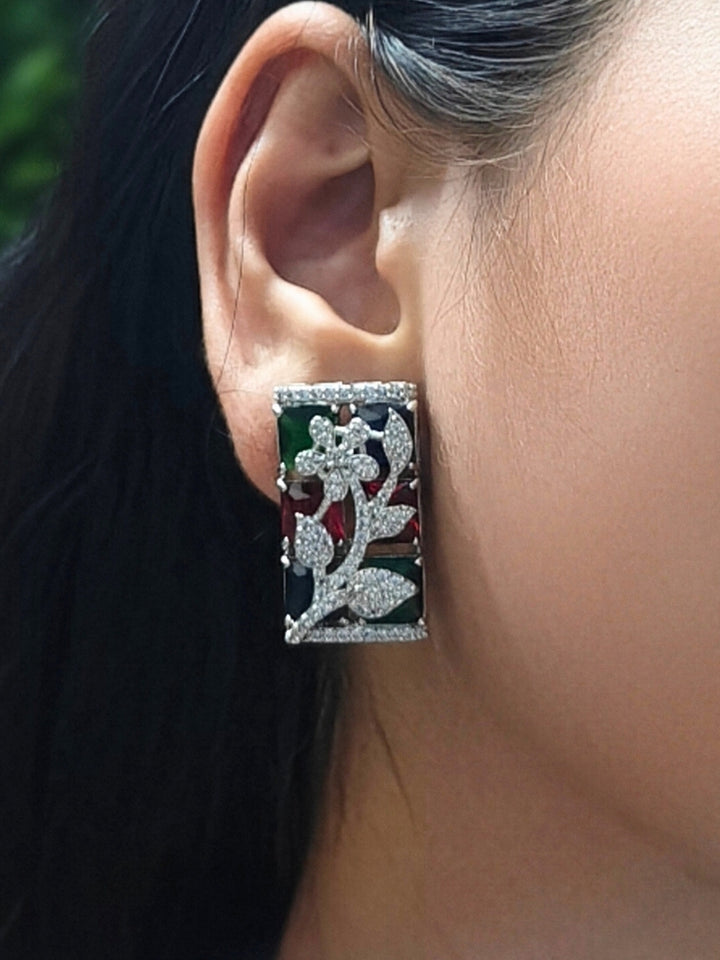 Close-up of a woman wearing an ornate Western (Silver Polish) Colored Stones Pendant set and earrings with American Diamond and Colored Stones. Modern bride styled in a luxury artificial Colored Stones Pendant Set for Party. Reception-ready look featuring a statement Colored Stones Pendant set.
