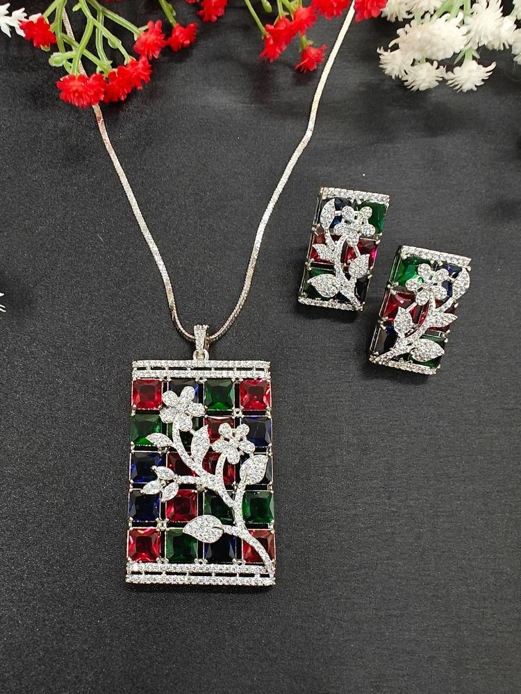 Close-up of an ornate Western (Silver Polish) Colored Stones Pendant set and earrings with American Diamond and Colored Stones. Modern styled in a luxury artificial Colored Stones Pendant Set for Party. Reception-ready look featuring a statement Colored Stones Pendant set.