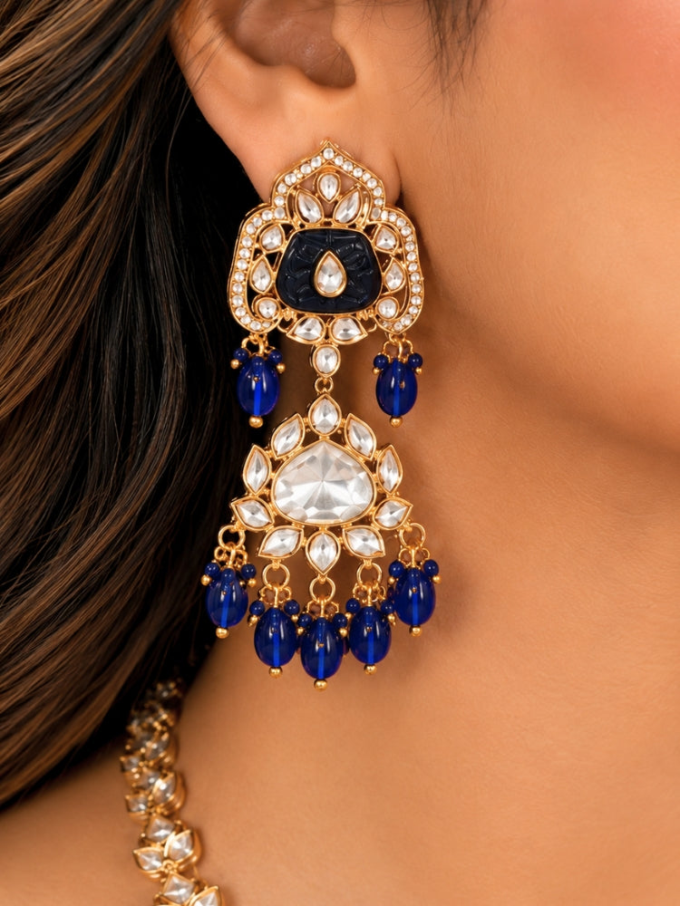Close-up of a woman wearing an ornate traditional (Gold Polish) Long jewellery set and earrings with Polki, Colored Stones and Tumble Beads. Woman wearing trending Polki artificial jewelry for the wedding season in India. Festive celebration look completed with premium imitation Polki jewelry.