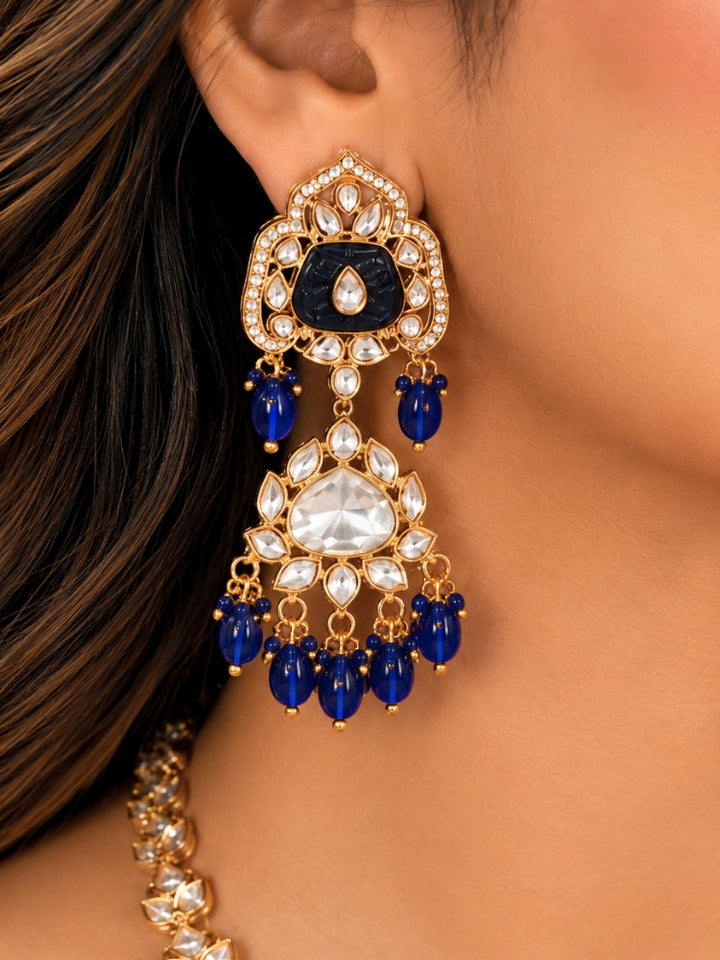 Close-up of a woman wearing an ornate traditional (Gold Polish) Long jewellery set and earrings with Polki, Colored Stones and Tumble Beads. Woman wearing trending Polki artificial jewelry for the wedding season in India. Festive celebration look completed with premium imitation Polki jewelry.