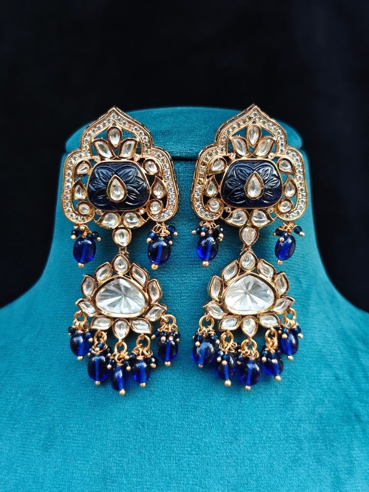 Close-up of an ornate traditional (Gold Polish) Long jewellery set and earrings with Polki, Colored Stones and Tumble Beads. Woman wearing trending Polki artificial jewelry for the wedding season in India. Festive celebration look completed with premium imitation Polki jewelry.