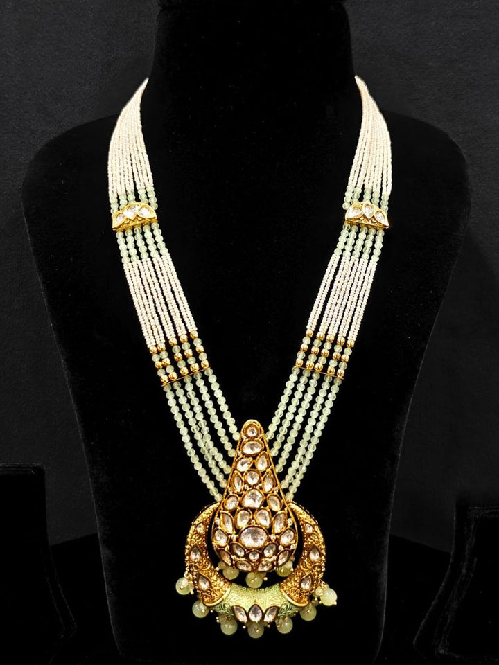 Close-up of an ornate traditional (Gold Polish) Mint Green Long jewellery set and earrings with Polki, Crystal Beads, Meenakari and Pearls. Festive Diwali look enhanced with a premium Polki artificial necklace. Saree styling inspiration with a Long Polki imitation jewelry piece.