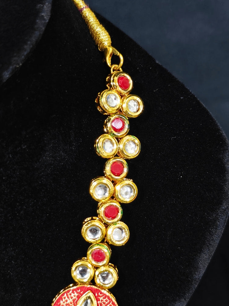 Close-up of an ornate traditional (Gold Polish) Red Kundan jewellery set and earrings with Kundan, Colored Stones, Meenakari and Crystal Beads. Mehendi ceremony look completed with a handcrafted Kundan jewelry set. Close-up of detailed Kundan stones in artificial wedding jewelry.