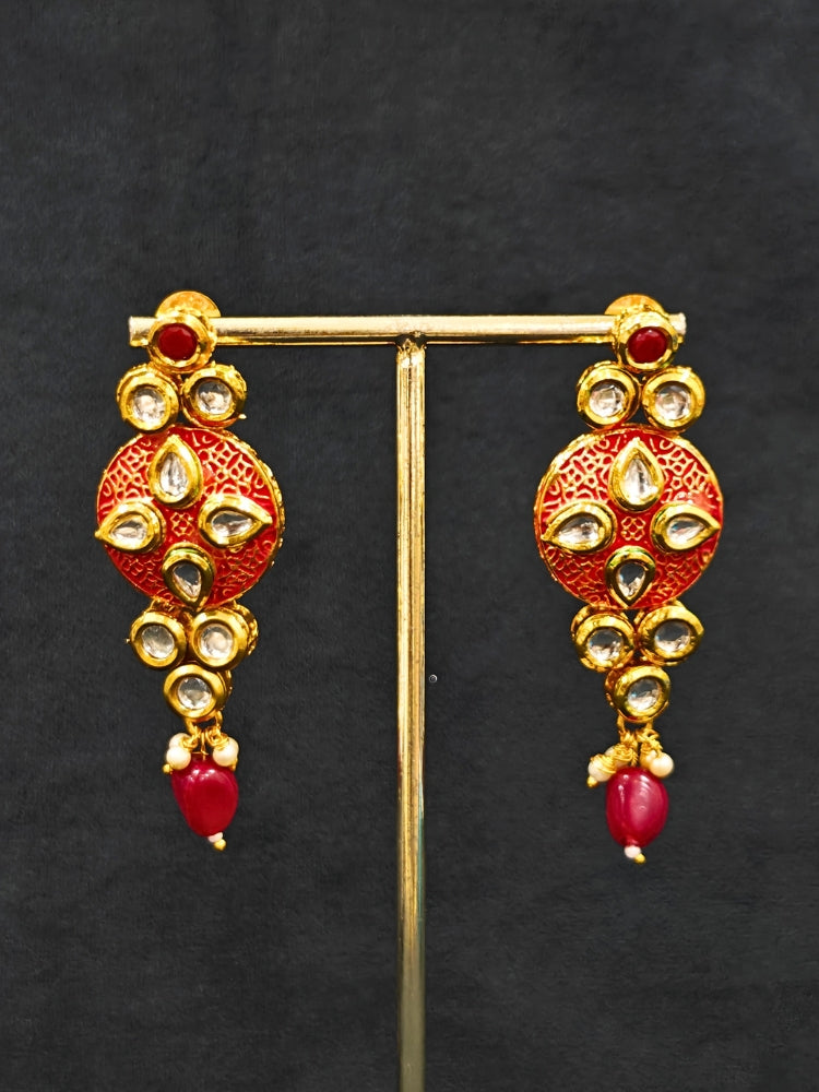 Close-up of an ornate traditional (Gold Polish) Red Kundan jewellery set and earrings with Kundan, Colored Stones, Meenakari and Crystal Beads. Mehendi ceremony look completed with a handcrafted Kundan jewelry set. Close-up of detailed Kundan stones in artificial wedding jewelry.