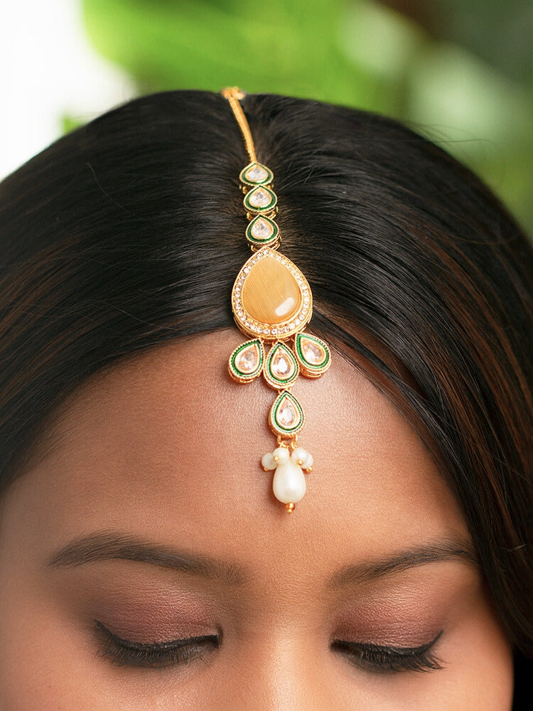 Close-up of a women wearing an ornate traditional Peach Choker jewellery set and earrings and maangtikka with Kundan, Monalisa Stone, American Diamonds, Beads and Reverse American Diamonds and tumble stones. A graceful woman wearing a trending Colored Stone necklace for a 2026 wedding celebration. Elegant wedding jewelry look featuring a premium artificial Colored Stone necklace.