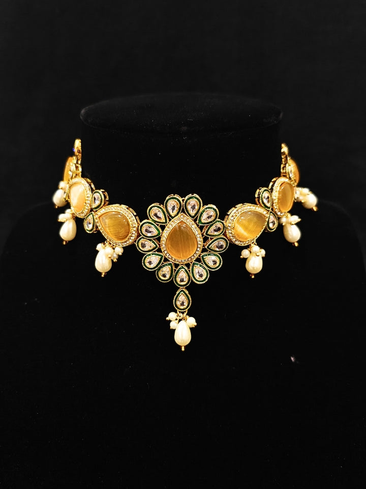 Close-up of an ornate traditional Peach Choker jewellery set and earrings and maangtikka with Kundan, Monalisa Stone, American Diamonds, Beads and Reverse American Diamonds and tumble stones. A graceful woman wearing a trending Colored Stone necklace for a 2026 wedding celebration. Elegant wedding jewelry look featuring a premium artificial Colored Stone necklace.