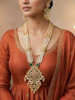 Close-up of a woman wearing an ornate traditional Peach Rajwadi gold Long jewellery set and earrings with Kundan, Meenakari work, crystal beads, pearls, American Diamonds, pearls, Tumble stones and Colored Stones. Woman wearing a bridal Rajwadi necklace for a reception function. Close-up of a handcrafted Rajwadi artificial jewelry set for bridal wear.