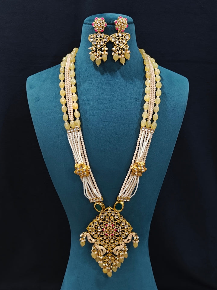 Close-up of an ornate traditional Peach Rajwadi gold Long jewellery set and earrings with Kundan, Meenakari work, crystal beads, pearls, American Diamonds, pearls, Tumble stones and Colored Stones. Close-up of a premium Rajwadi artificial necklace under 10000.
Close-up of a handcrafted Rajwadi artificial jewelry set.