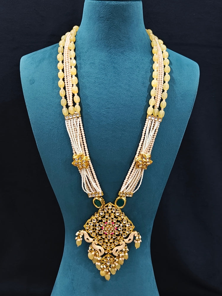 Close-up of an ornate traditional Peach Rajwadi gold Long jewellery set and earrings with Kundan, Meenakari work, crystal beads, pearls, American Diamonds, pearls, Tumble stones and Colored Stones. Close-up of a premium Rajwadi artificial necklace under 10000.
Close-up of a handcrafted Rajwadi artificial jewelry set.
