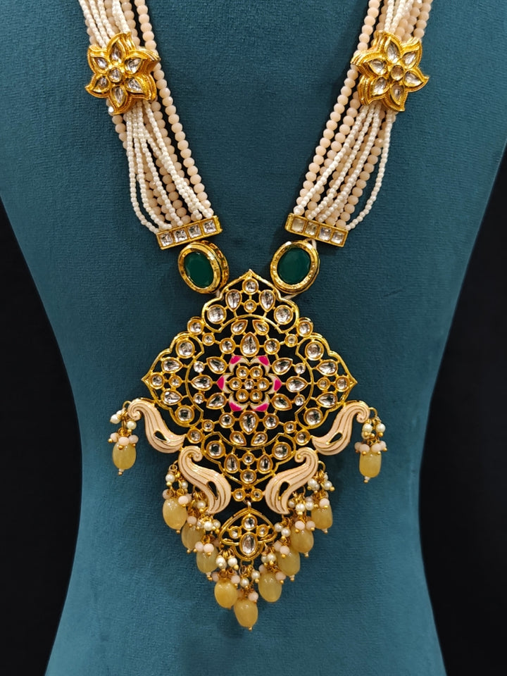 Close-up of an ornate traditional Peach Rajwadi gold Long jewellery set and earrings with Kundan, Meenakari work, crystal beads, pearls, American Diamonds, pearls, Tumble stones and Colored Stones. Close-up of a premium Rajwadi artificial necklace under 10000.
Close-up of a handcrafted Rajwadi artificial jewelry set.
