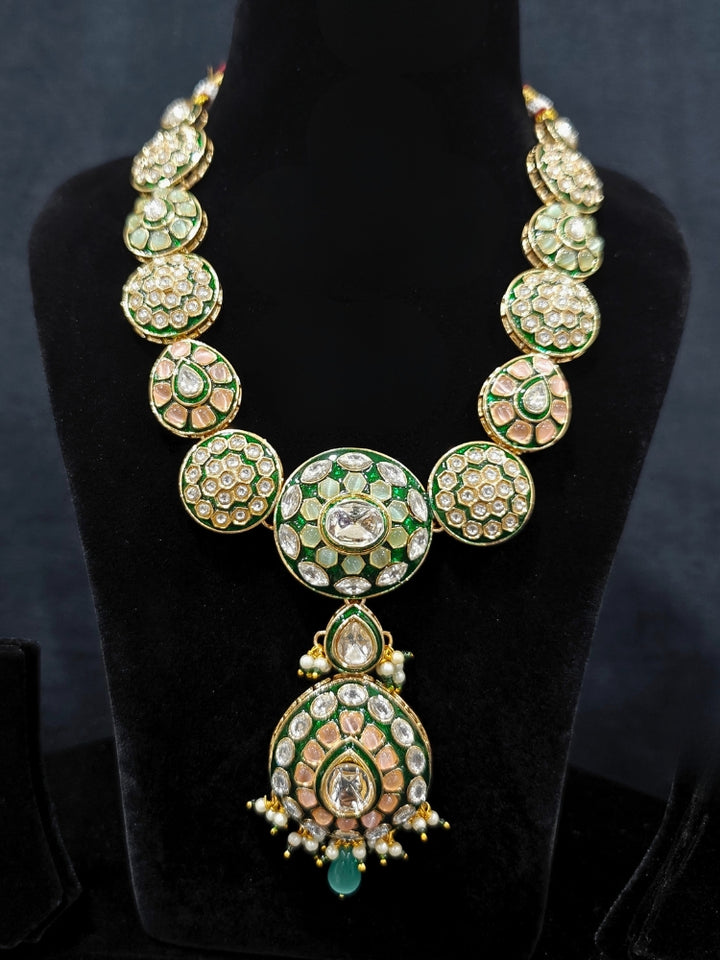 Close-up of an ornate traditional Peach Jewelry Set, Earrings and Mangtikka with Kundan and Colored Stones. Bride wearing a traditional Kundan artificial necklace set for her wedding ceremony. Woman wearing trending Kundan artificial jewelry for wedding season in India.