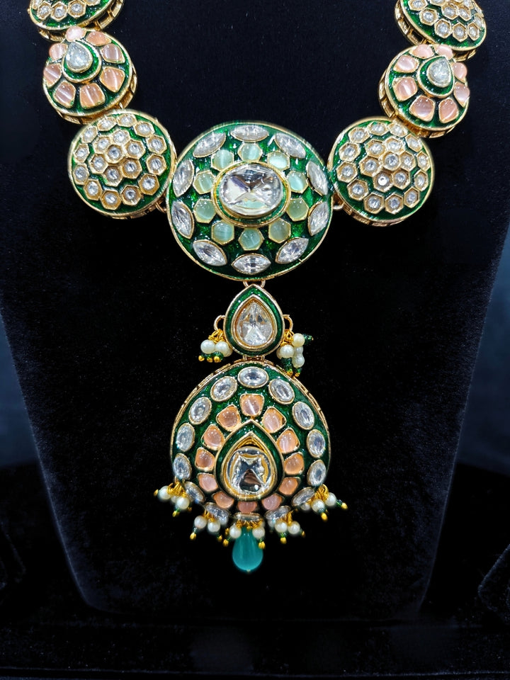 Close-up of an ornate traditional Peach Jewelry Set, Earrings and Mangtikka with Kundan and Colored Stones. Bride wearing a traditional Kundan artificial necklace set for her wedding ceremony. Woman wearing trending Kundan artificial jewelry for wedding season in India.