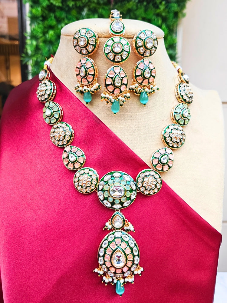 Close-up of an ornate traditional Peach Jewelry Set, Earrings and Mangtikka with Kundan and Colored Stones. Bride wearing a traditional Kundan artificial necklace set for her wedding ceremony. Woman wearing trending Kundan artificial jewelry for wedding season in India.