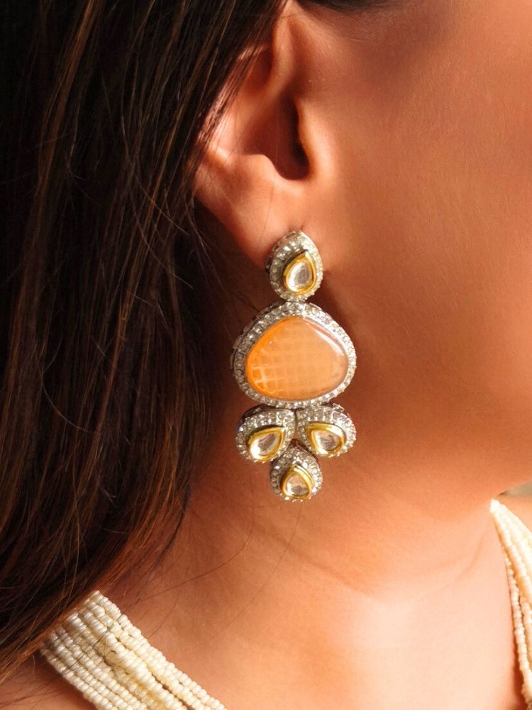 A woman in a gold embroidered outfit smiles, showcasing the Peacoski Peach Tamanna Necklace Set and matching earrings. Her soft makeup highlights the elegance of this statement jewelry ensemble.