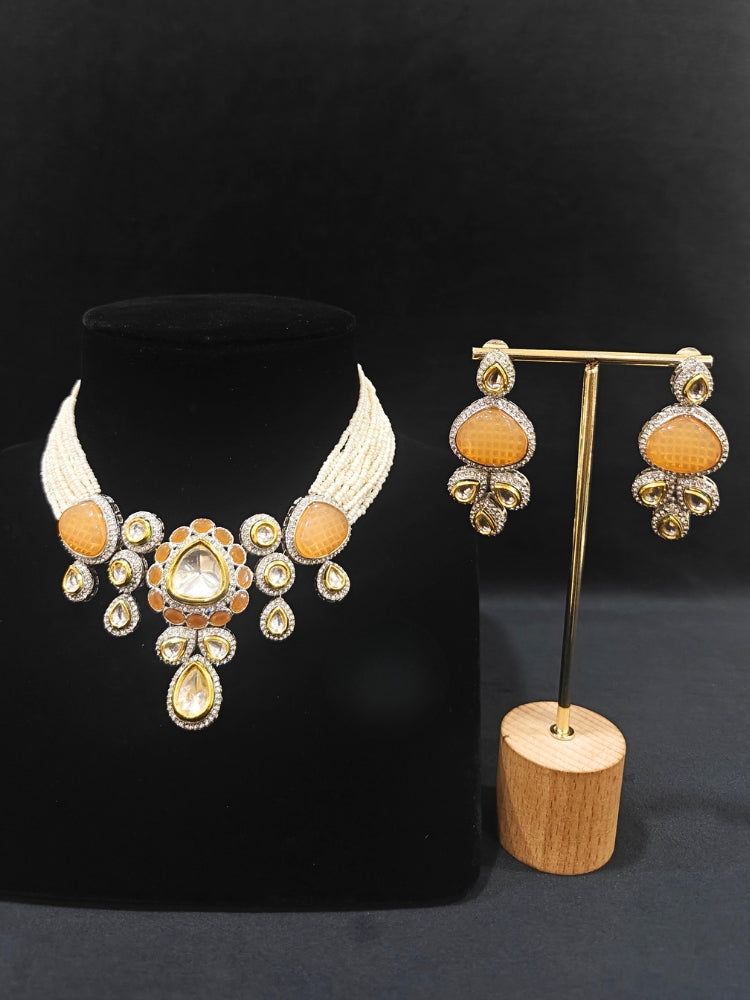 Close-up of an ornate traditional Peach Collar Kundan jewellery set and earrings with American diamonds, Monalisa stone, Pearls, Kundan and Colored Stones. Festive Diwali outfit paired with a premium Kundan jewelry piece. A trending Kundan artificial jewelry for wedding season in India.