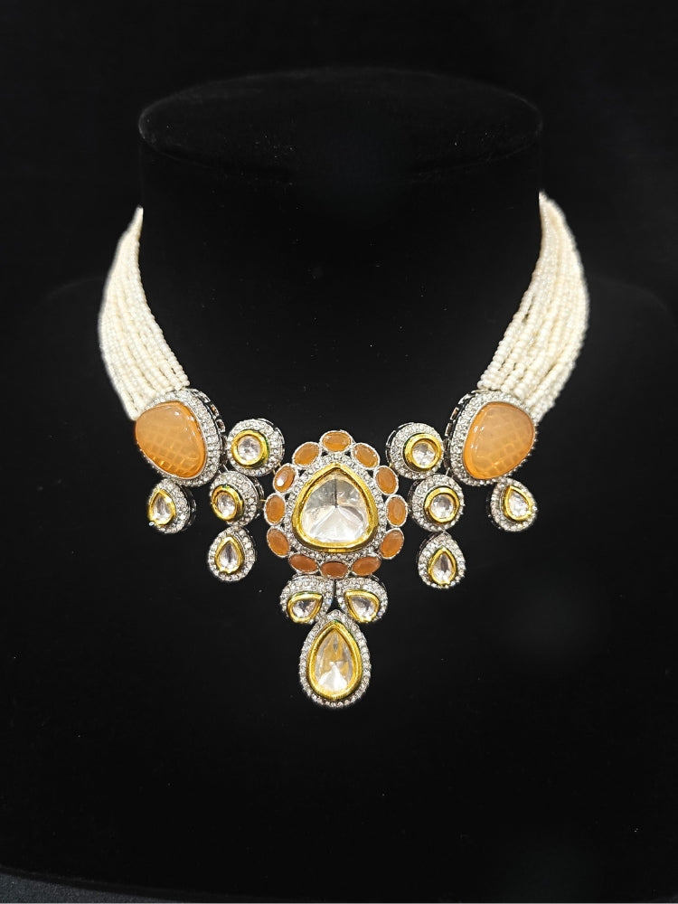 Close-up of an ornate traditional Peach Collar Kundan jewellery set and earrings with American diamonds, Monalisa stone, Pearls, Kundan and Colored Stones. Festive Diwali outfit paired with a premium Kundan jewelry piece. A trending Kundan artificial jewelry for wedding season in India.