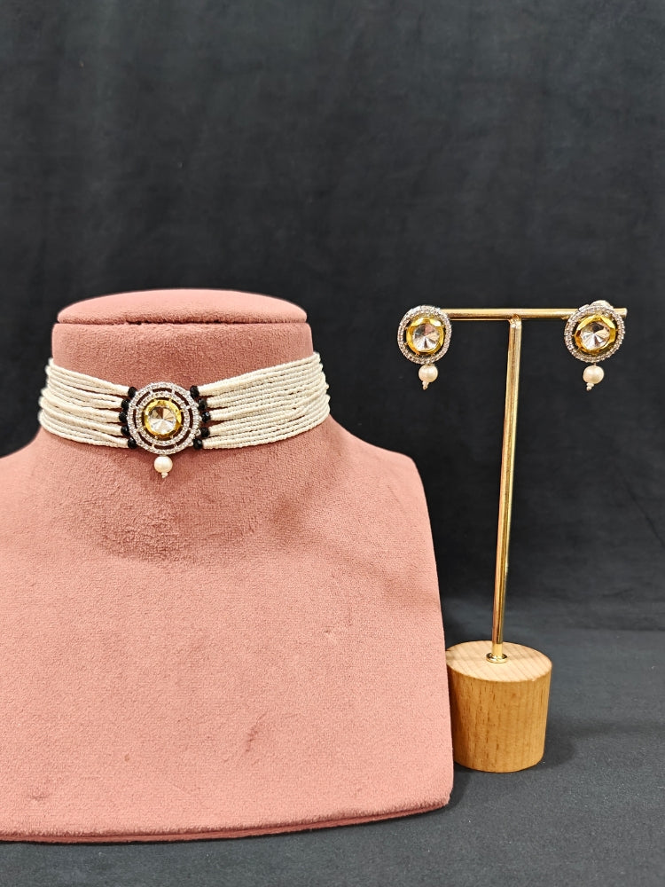 Close-up of an ornate traditional Black Choker jewellery set and earrings with Kundan, American Diamond, Crystal Beads and Pearls. Festive saree styling with a premium artificial Pearls necklace. Mehendi ceremony look completed with a handcrafted Pearls jewelry set.