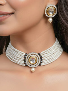 Close-up of a woman wearing an ornate traditional Dark Green Choker jewellery set and earrings with Kundan, American Diamond, Crystal Beads and Pearls. Festive saree styling with a premium artificial Pearls necklace. Mehendi ceremony look completed with a handcrafted Pearls jewelry set.