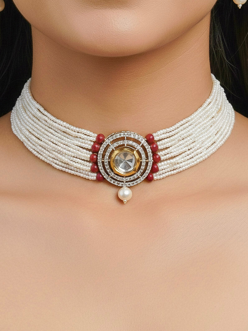 Close-up of a woman wearing an ornate traditional Red Choker jewellery set and earrings with Kundan, American Diamond, Crystal Beads and Pearls. Festive saree styling with a premium artificial Pearls necklace. Mehendi ceremony look completed with a handcrafted Pearls jewelry set.