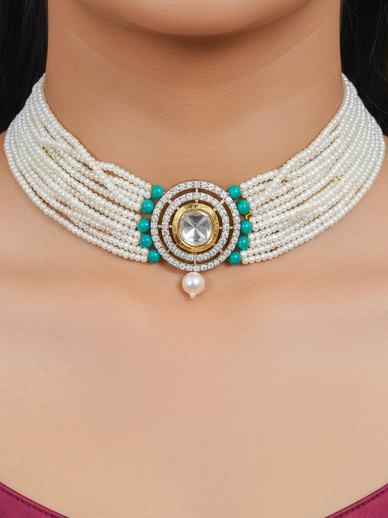 Close-up of a woman wearing an ornate traditional Teel Choker jewellery set and earrings with Kundan, American Diamond, Crystal Beads and Pearls. Festive saree styling with a premium artificial Pearls necklace. Mehendi ceremony look completed with a handcrafted Pearls jewelry set.