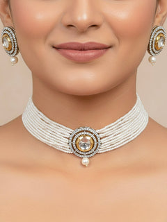Close-up of a woman wearing an ornate traditional White Choker jewellery set and earrings with Kundan, American Diamond, Crystal Beads and Pearls. Festive saree styling with a premium artificial Pearls necklace. Mehendi ceremony look completed with a handcrafted Pearls jewelry set.
