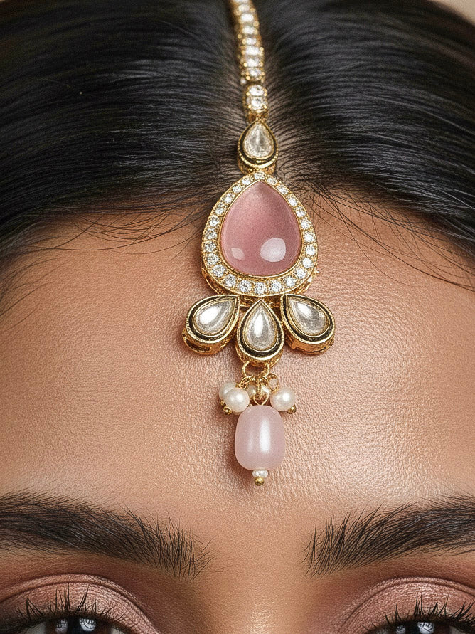 Close-up of a woman wearing an ornate traditional Pink Choker jewellery set and earrings and maangtikka with Kundan, Monalisa Stone, American Diamonds, Beads and Reverse American Diamonds and tumble stones. A graceful woman wearing a trending Colored Stone necklace for a 2026 wedding celebration. Elegant wedding jewelry look featuring a premium artificial Colored Stone necklace.