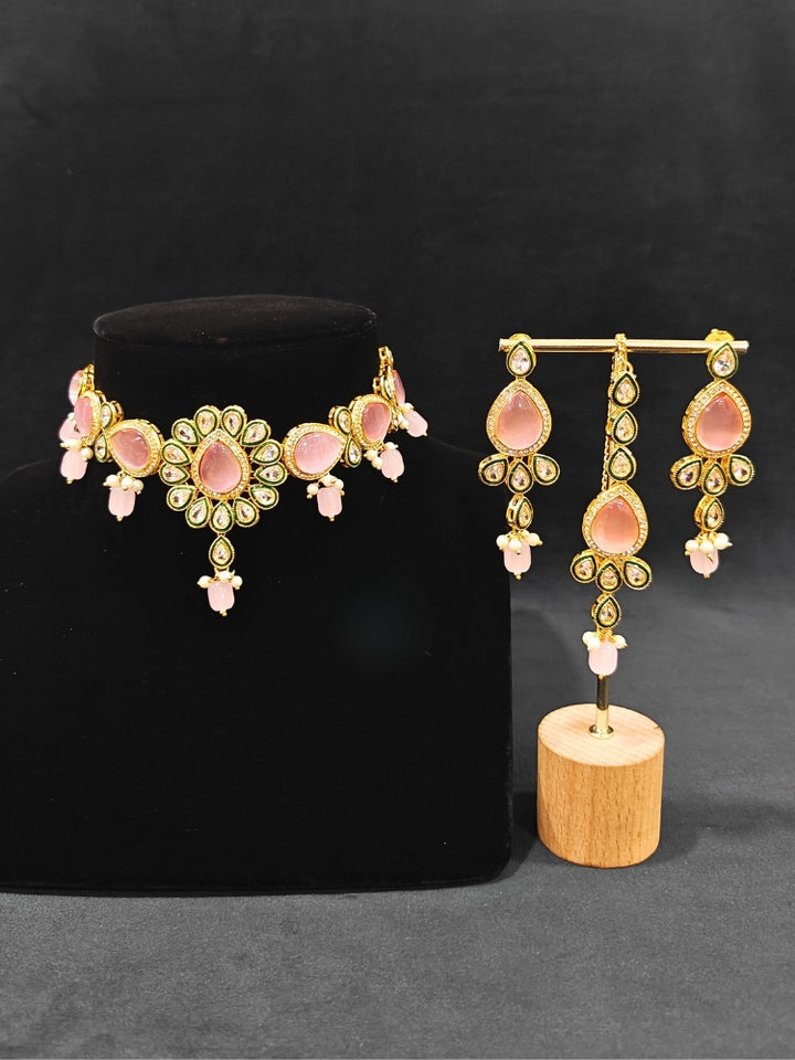 Close-up of an ornate traditional Pink Choker jewellery set and earrings and maangtikka with Kundan, Monalisa Stone, American Diamonds, Beads and Reverse American Diamonds and tumble stones. A graceful woman wearing a trending Colored Stone necklace for a 2026 wedding celebration. Elegant wedding jewelry look featuring a premium artificial Colored Stone necklace.
