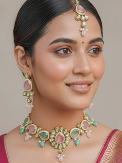 Close-up of a woman wearing an ornate traditional Pink & Green Choker jewellery set and earrings and maangtikka with Kundan, Monalisa Stone, American Diamonds, Beads and Reverse American Diamonds and tumble stones. A graceful woman wearing a trending Colored Stone necklace for a 2026 wedding celebration. Elegant wedding jewelry look featuring a premium artificial Colored Stone necklace.