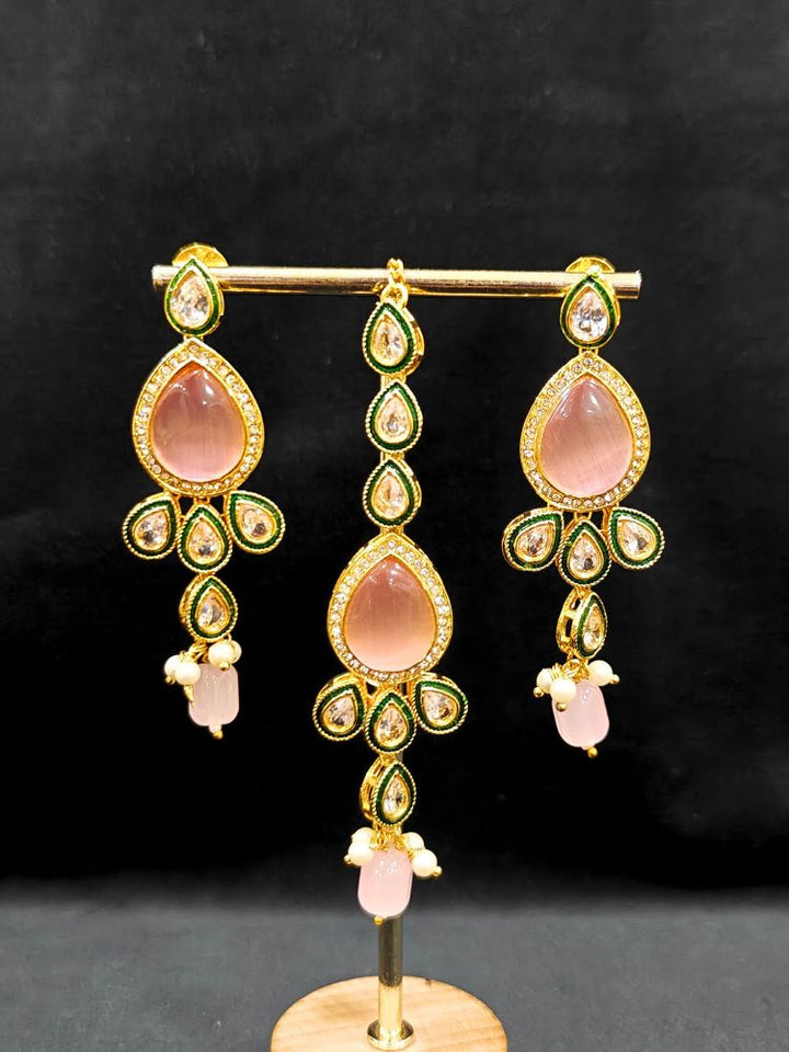 Close-up of an ornate traditional Pink & Green Choker jewellery set and earrings and maangtikka with Kundan, Monalisa Stone, American Diamonds, Beads and Reverse American Diamonds and tumble stones. A graceful woman wearing a trending Colored Stone necklace for a 2026 wedding celebration. Elegant wedding jewelry look featuring a premium artificial Colored Stone necklace.